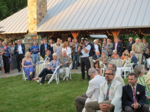 Attendees at Saturday’s fund-raiser pause from conversations in and around the outdoor pavilion as the Lenfests welcome them to the Lenfest Center at the ChesLen Preserve in Newlin Township.