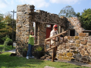 Artist Adrian Martinez (right) gets into position at Martin’s Tavern in Marshallton so his wife, Leah Martinez, can photograph the scene for use in one of the paintings that will comprise the 2015 exhibit, “History in the Making: A Contemporary Artist’s View of Chester County, 1750-1800.”