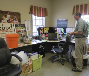 Larry Welsch, executive director of the Chester County Food Bank, surveys some of the current, cramped office space, which features overflow storage on the floor.