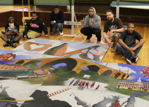 Teens show off the finished Darkness to Light mural at an unveiling ceremony at the Bridge Academy and Community Center in Coatesville.