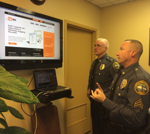 Coatesville Police Chief Jack Laufer (left) and Sgt. Rodger Ollis demonstrate the ease with which citizens can contact police anonymously through a new phone app.