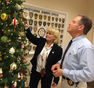 Chester County Sheriff Carolyn “Bunny” Welsh and Chief Deputy Sheriff George P. March scan the tree for their favorite ornaments from a collection handcrafted by March's mother, who died in September. 