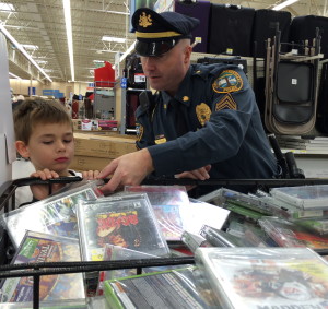 Sgt. Rodger Ollis helps his shopper sort through a large bin  of DVDs to make the right selection. Later, the purchase would be wrapped by a crew that included his wife, Michele.