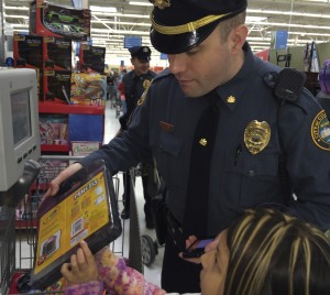 Coatesville Cpl. Jonathan Shave offers assistance to his shopper at the price-checker. Behind him, Det. Kevin Campbell waits for his turn.