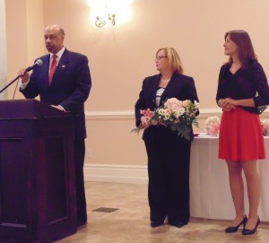 Chester County Commissioner Terence Farrell introduces Empowered Young Woman award-winner Christine Luczka (right). She is joined be , vice president of the Chester County Women's Commission.