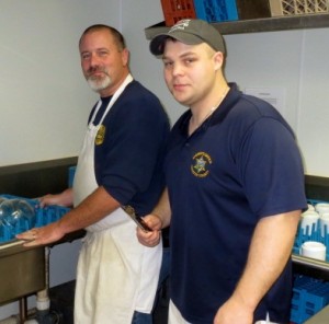 Sheriff Deputies Dave Reeves (left) and Ben Tobin display their dish-washing prowess in the kitchen.