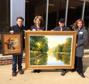 Artist Shawn Faust (left) displays “Mother’s Day,” the painting he donated to the 65th Annual Chadds Ford Art Sale and Show, as co-chairs Frances Galvin and Lynda Nadin (right) hold “Along the Brandywine” with featured artist J. Wayne Bystrom.