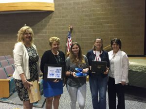 Coatesville High School student Hannah Williams (center) was recognized during the school board meeting for winning a shoe design contest for Autism Awareness Month by the CHester COunty Intermediate Unit. Pictured with (left to right) Brenda Eaton and Dr. Anita Riccio of the CCIU, school board member Brenda Geist and CASD superintendent Dr. Cathy Taschner.