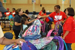 Aja Thompson of the CYI helped six-year-old Giselle Nunez pick out a new backpack for first grade.