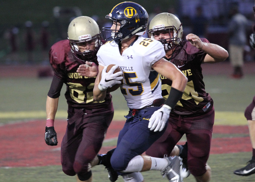 Unionville's Jack Adams fights for yards against Avon Grove, Friday. Jim Gill photo.